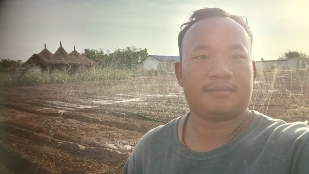 The author standing in front of a sprinkler system at his garden business.