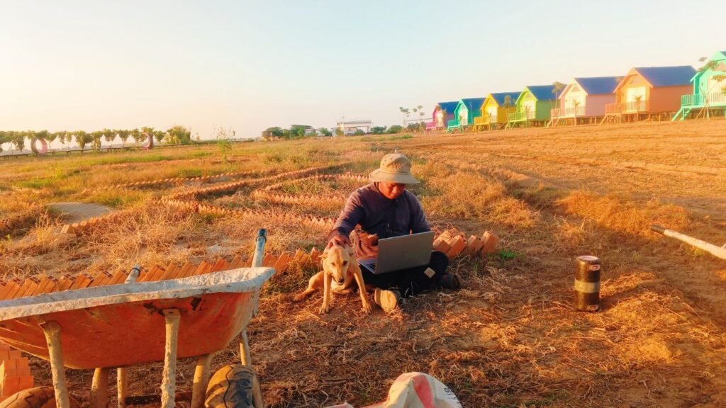My 'Office' View: Writing business plans right on the ground with my assistant Dudo, while the sun sets over the bungalows we built by hand.