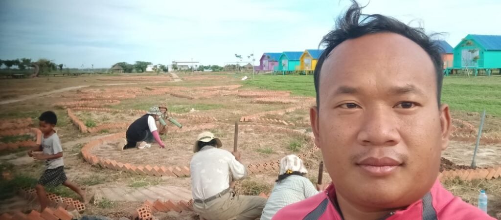 A manager taking a selfie with his team working in the background, showing the reality of hands-on leadership.