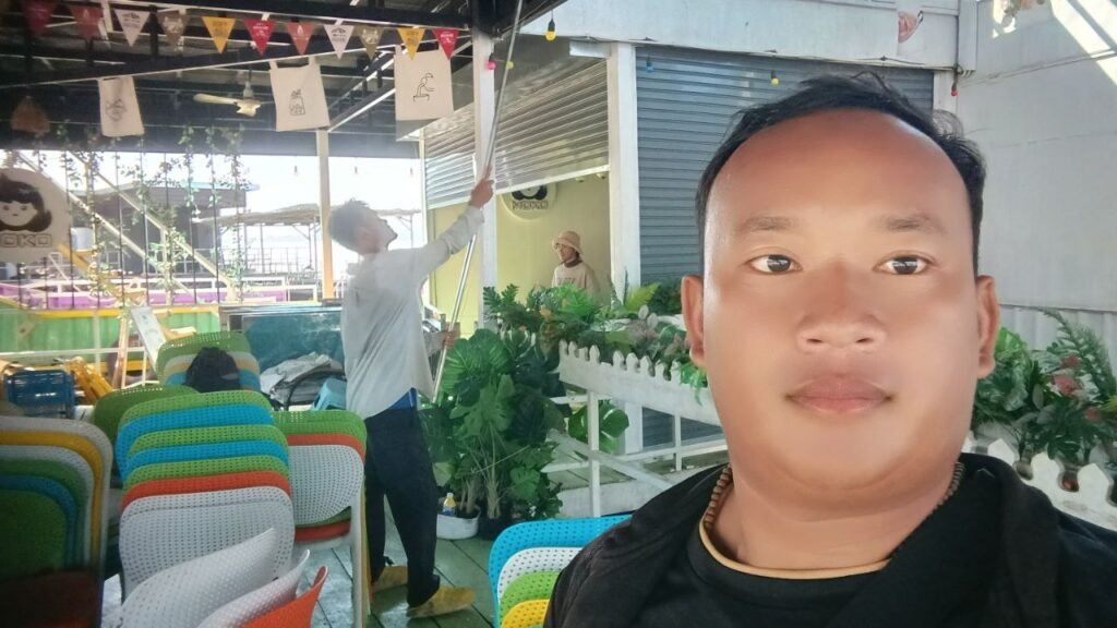 Small business owner at Dream Garden restaurant watching team member adjust overhead lights with a stick – the moment that sparked our creative idea.