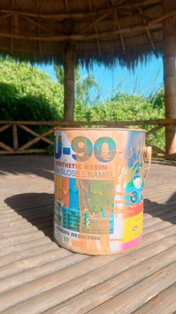Used paint can sitting on a wooden deck, representing the low-cost marketing strategy of painting a boat pink.