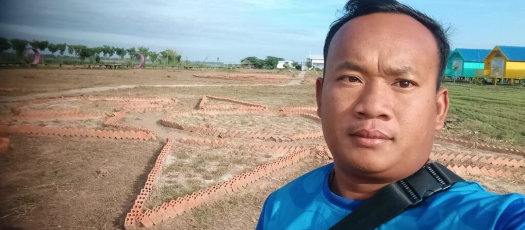 Dream Garden owner Phonh standing in front of a DIY brick star garden layout.