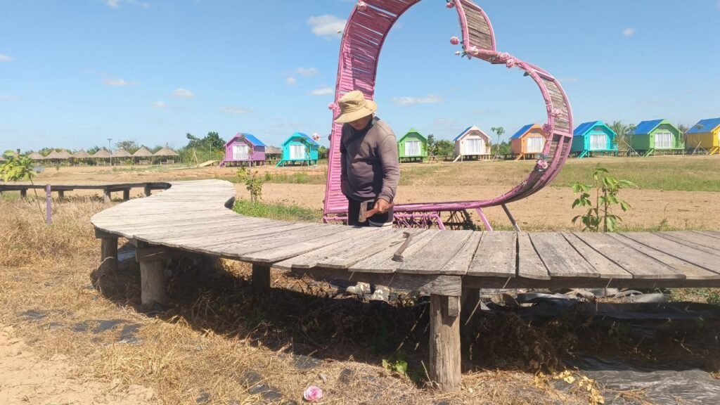 Maintaing the structures at Dream Garden near the pink heart decoration, showing how practical construction skills are built over time.