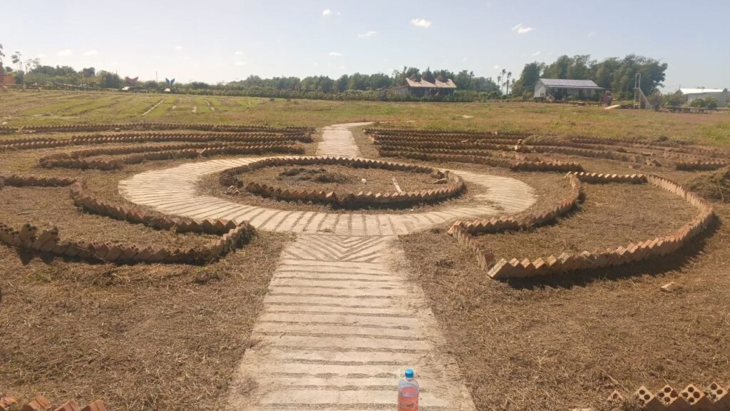 Dry brown field with brick outlines marking the future garden paths.