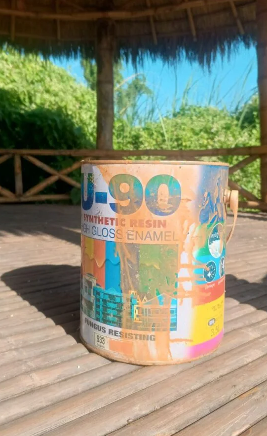 Can of U-90 high gloss enamel paint sitting on a bamboo deck, used to paint a tour boat in Kratie, Cambodia.